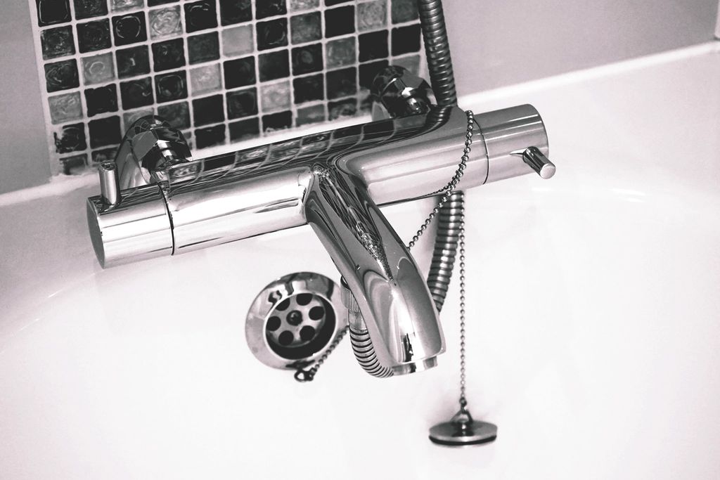Mitigeur thermostatique chromé au-dessus d'une baignoire