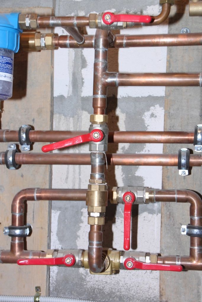 Installation en cuivre: vannes d'arrêt rouges, raccords en laiton et filtre à eau